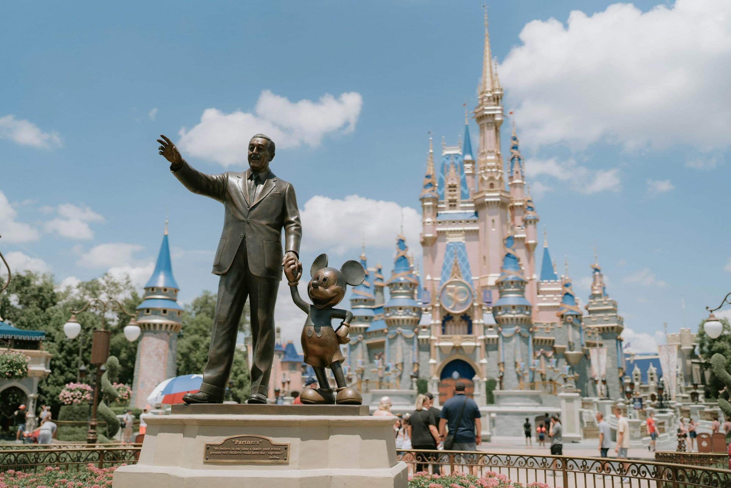 Estátua de Walt Disney e Mickey diante do castelo em Orlando